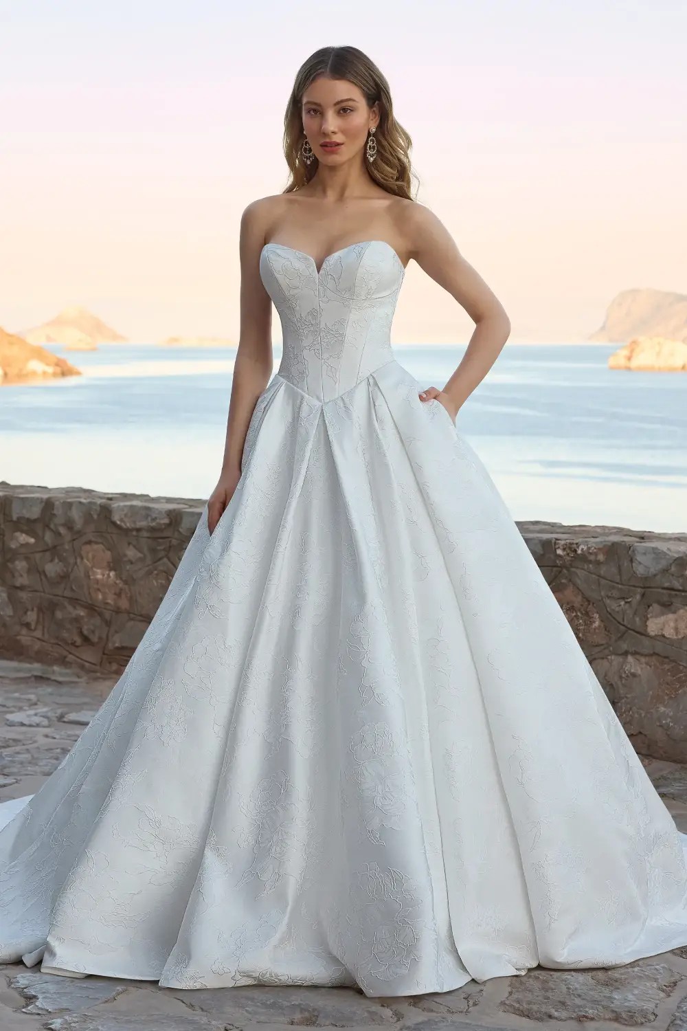 Model wearing a white gown by Sophia Tolli